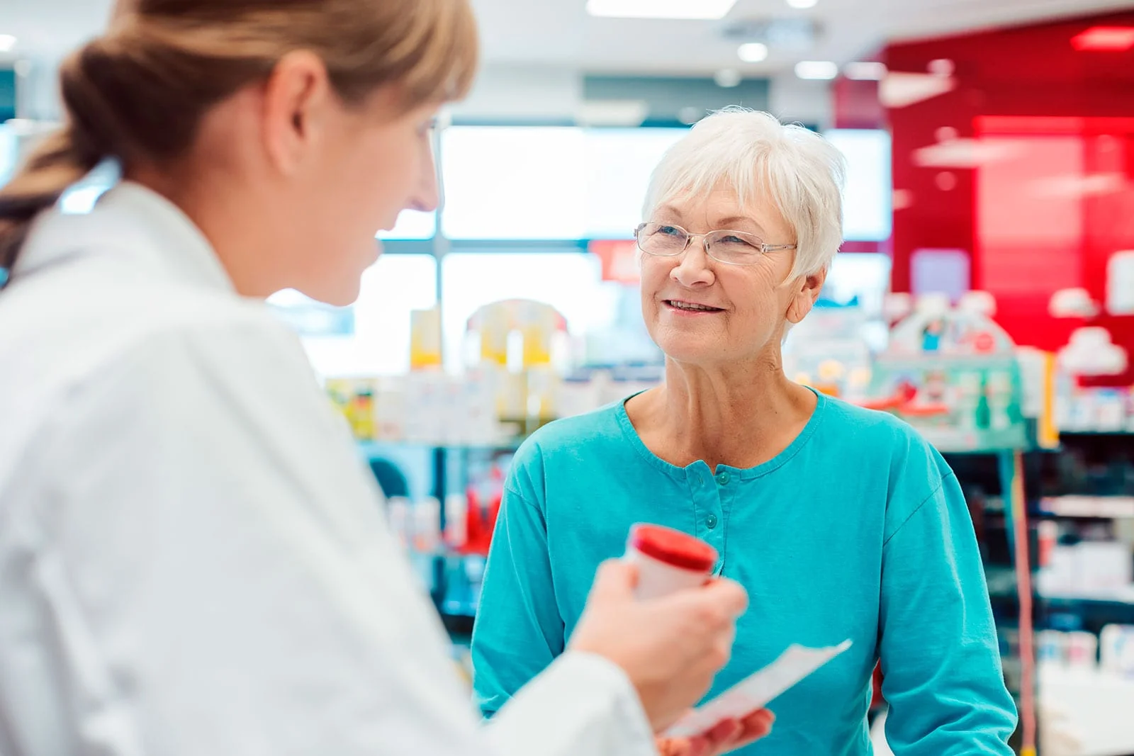 Apteekin henkilökunta neuvoo asiakasta